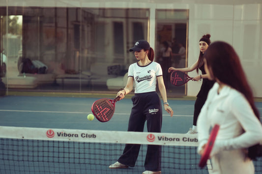 Women enjoying a padel match indoors at Vibora Club, Baghdad, showcasing athletic activity.