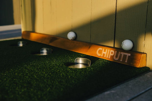 Close-up of a golf training aid featuring artificial turf and golf balls with 'Chiputt' text.