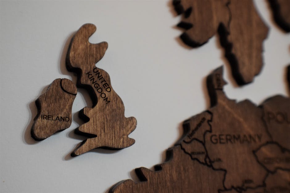 Close-up of wooden puzzle pieces shaped like the UK and Ireland on a white background.
