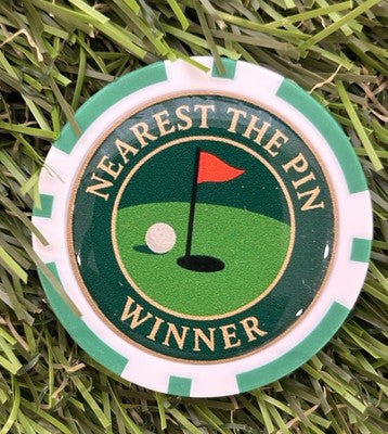 Assorted Scotty Dog Golf markers, pitchforks, and accessories displayed on a green golf course.