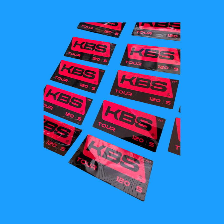 Selection of Dynamic Gold and KBS golf shaft replacement labels displayed on iron shafts