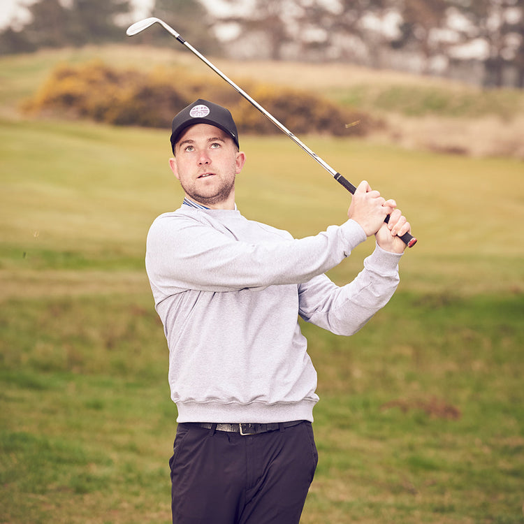 Aperiron golf clothing range for men, women, and children displayed on a UK golf course backdrop, showcasing performance polos and jumpers for 2026.